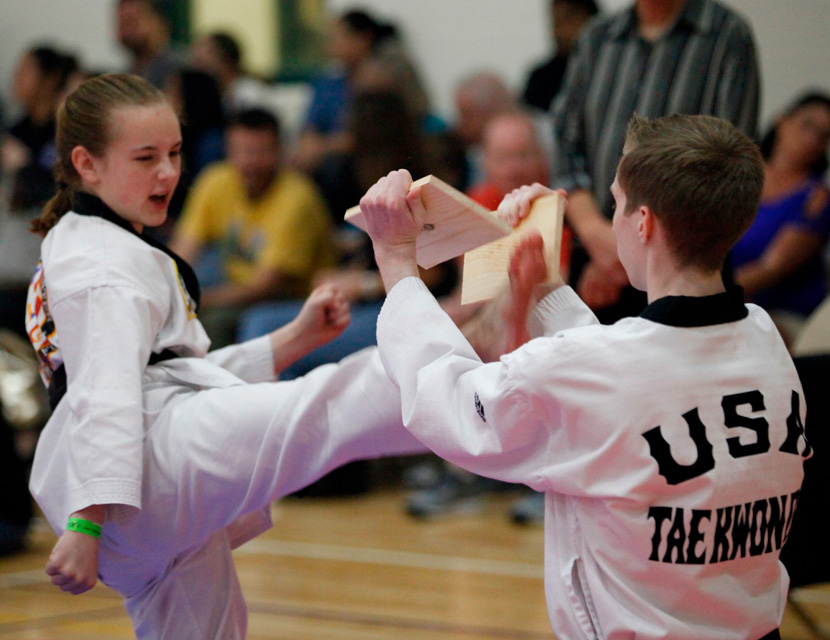 girl breaking a board with a flying kick